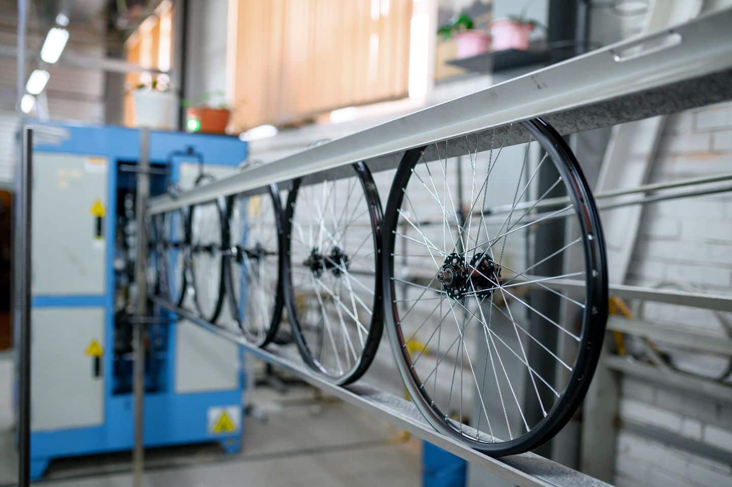 Vielfältige Anwendungen von Aluminium: Aluminium-Fahrradräder am Fließband. Fahrradfelgen mit Naben und Speichen in der modernen Herstellung.